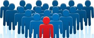 Cartoon representation of a red person standing in front of a crowd of blue people.