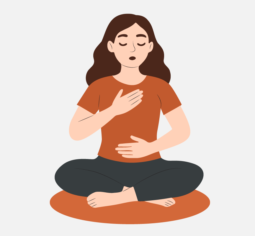 A woman meditating with her legs crossed and her hands on her chest and stomach.