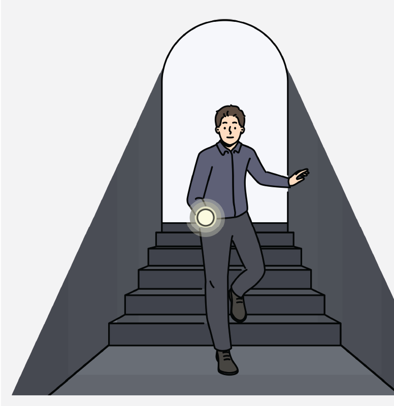 A man with a flashlight walking down a dark staircase