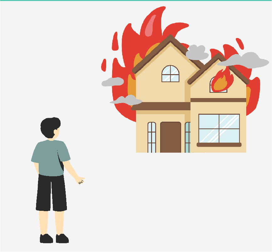 A boy looking at a house on fire.