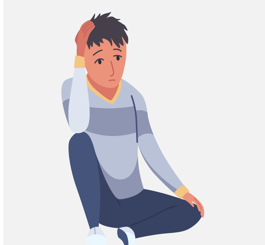 A sad-looking boy sitting on the ground.