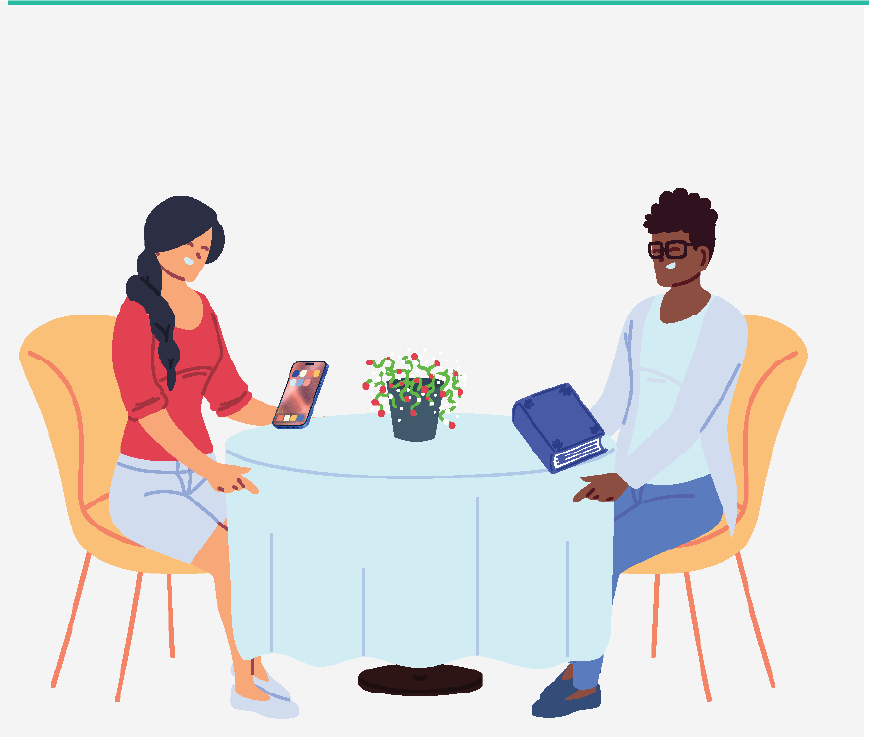 Imagen de dos mujeres sentadas en una mesa, una está leyendo un libro y la otra está mirando su teléfono. Están esperando a que les sirvan la comida.