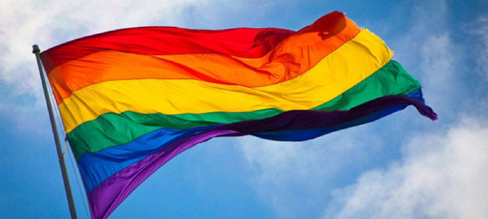 Image of a Rainbow flag flapping in the wind.